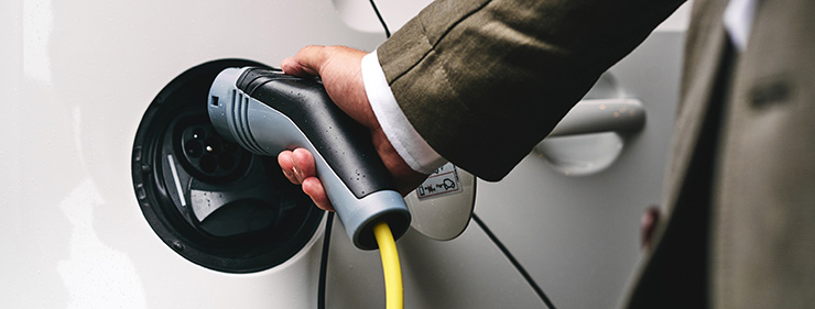 Person charging an electric vehicle at home